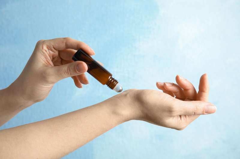 topical application of an essential oil to the wrist using a roller bottle.